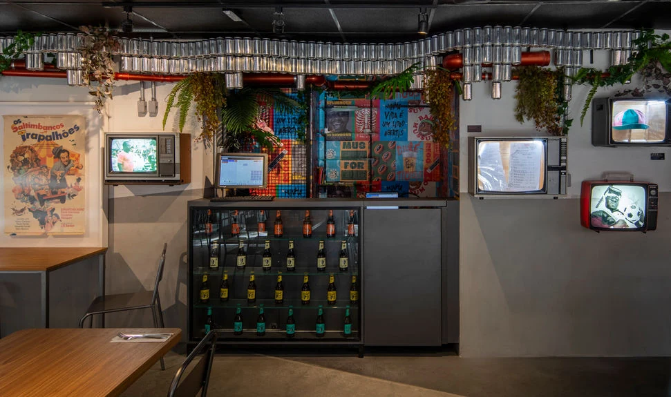 O interior do Bar do Mussum, com mesas e objetos que compõem o ambiente.